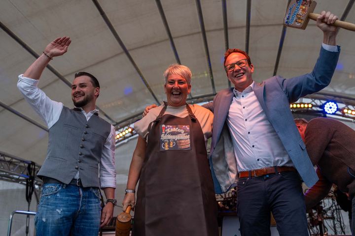 Drei Menschen feiern gemeinsam auf einer Eventbühne