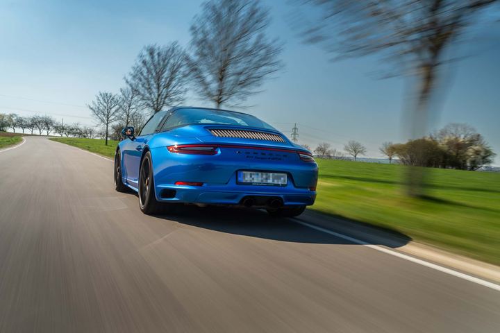 Blauer Porsche in dynamischer Fahraufnahme